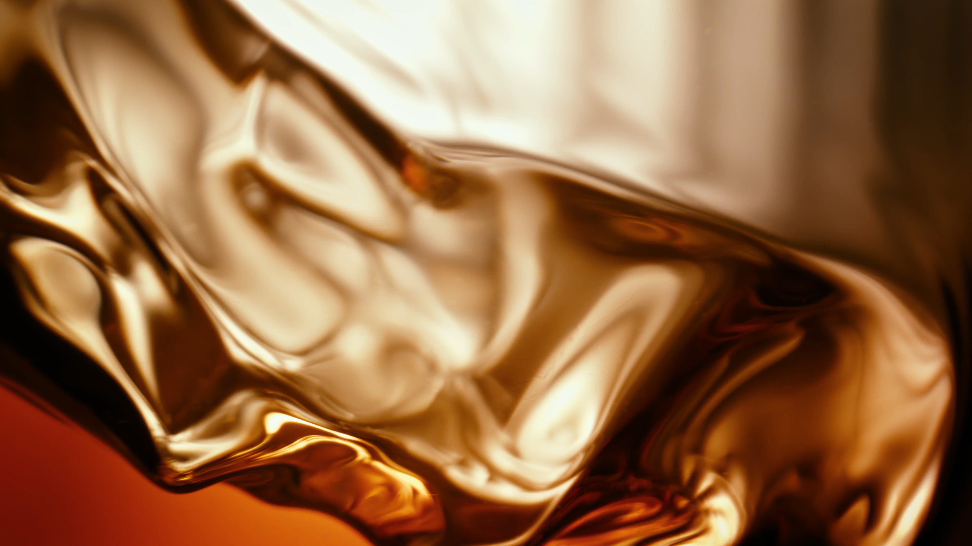 Close-up of amber Bowmore whisky flowing through sculpted glass