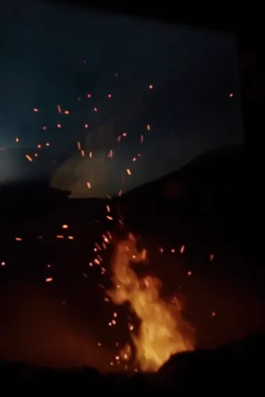 Embers rising from fire against dark background.