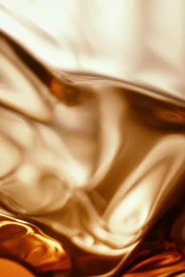 Close-up of amber Bowmore whisky flowing through sculpted glass