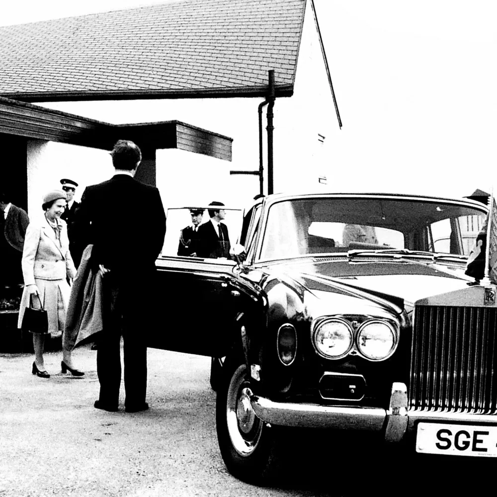 HM Queen with Rolls Royce in foreground.