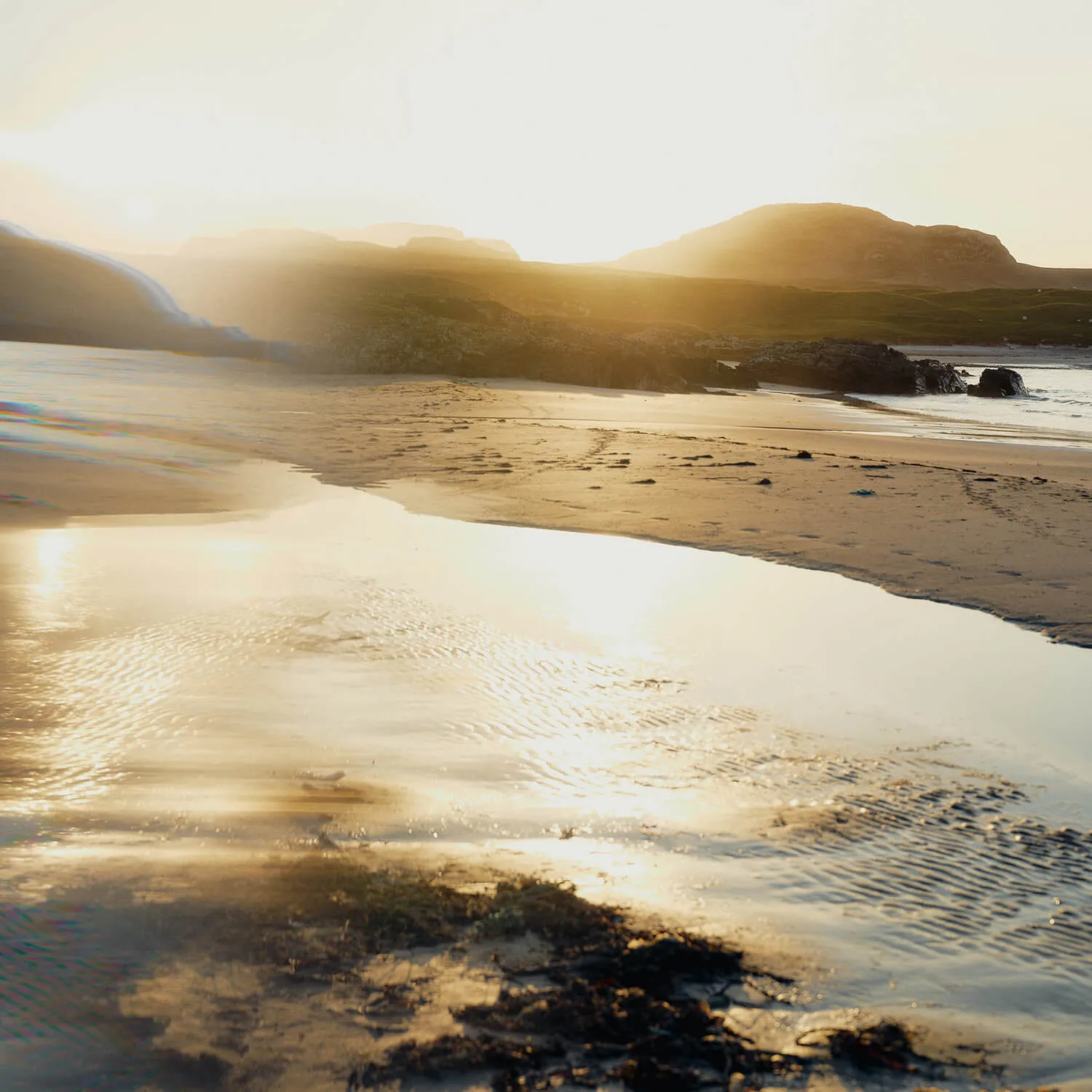 Image of sunlight reflecting on the sand and water on Islay