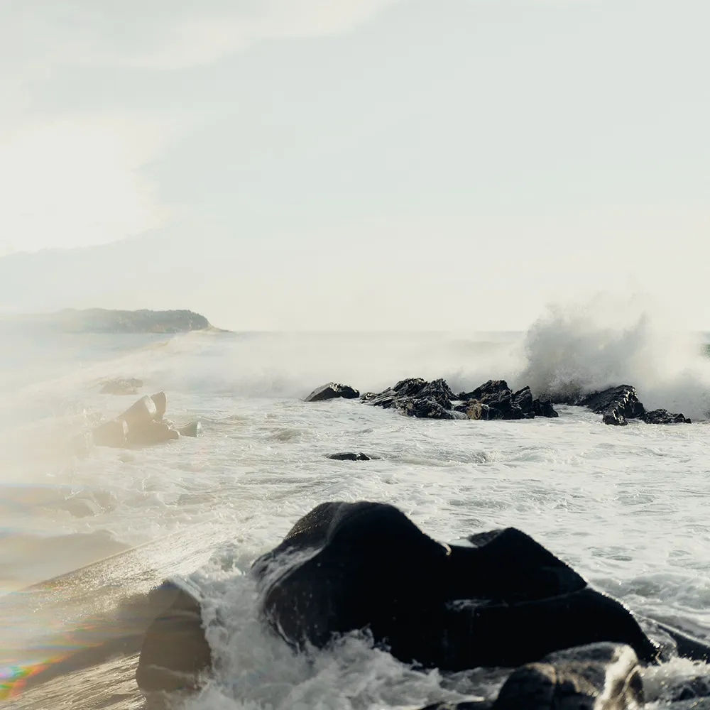 Wild, frothy seas breaking over black rock